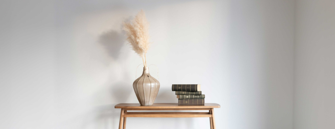 Kleiner Tisch mit Vase, Blume und ein Stapel Bücher